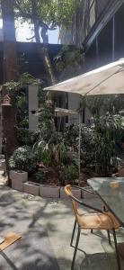un patio con mesa, silla y sombrilla en ICCE HOTEL, en Santiago