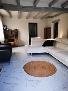 uma sala de estar com dois sofás brancos e um tapete em Maison côté jardin em Sevran