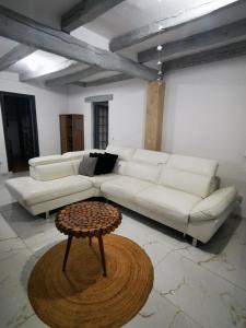uma sala de estar com um sofá branco e uma mesa em Maison côté jardin em Sevran