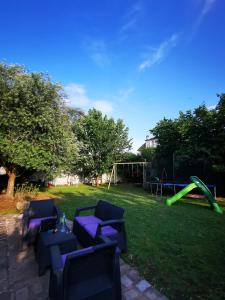 um quintal com um parque infantil com sofás azuis e um conjunto de jogos em Maison côté jardin em Sevran