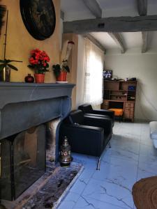 uma sala de estar com uma lareira com cadeiras e uma mesa em Maison côté jardin em Sevran