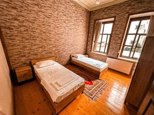 a room with two beds and a brick wall at Müslüm Ağa Mansion & Villa in Trabzon