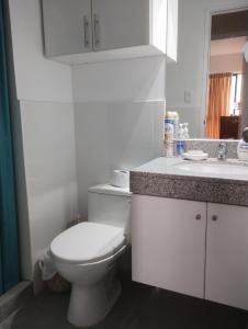 a white bathroom with a toilet and a sink at Habitación con baño privado desayuno incluído en casa de familia in Lima