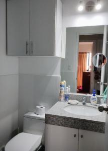 a bathroom with a toilet and a sink and a mirror at Habitación con baño privado y desayuno incluído en casa de familia in Lima
