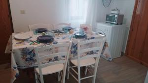 a dining room table with chairs and a table cloth at Domo Mea in Miniera dellʼArgentiera