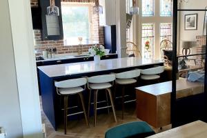 a kitchen with a counter and bar stools at Stunning 3 bedroom Victorian home near Pollok country park in Glasgow