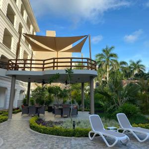 a patio with two lounge chairs and a canopy at Palacio Huatulco - 2I in Santa Maria Huatulco