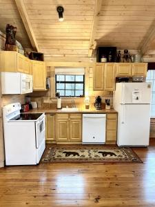 cocina con electrodomésticos blancos y techo de madera en Crazy Bear - Motorcycle Friendly Home with Hot Tub and Grill, en Tellico Plains