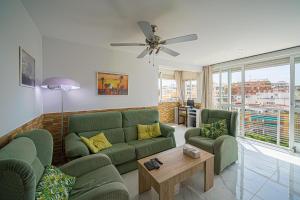 een woonkamer met een groene bank en 2 stoelen bij Piso Manuel Playa Poniente in Benidorm