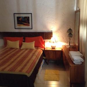 una camera con 2 letti e un comodino con lampada di Departamento frente a Parque Cívico a Mendoza