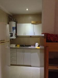 eine Küche mit weißen Schränken und einem Waschbecken in der Unterkunft Departamento frente a Parque Cívico in Mendoza