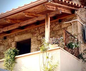 un edificio con balcone con piante in vaso di Jasmine Stoupa a Stoupa