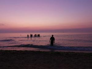 a man standing in the water at the beach at Camper Niklas in Vama Veche