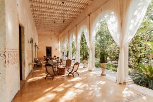 un gran pasillo con sillas y mesas en un edificio en Hacienda Shambalante, en Izamal