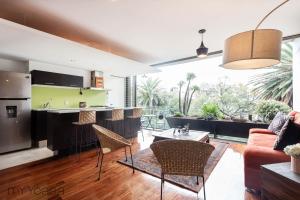cocina y sala de estar con mesa y sillas en Destination Condesa @Tamaulipas Loft, en Ciudad de México
