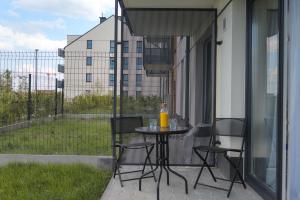 a patio with a table and chairs on a balcony at Stunning Apartment Hokejowa with Terrace & Parking by Renters in Gdańsk
