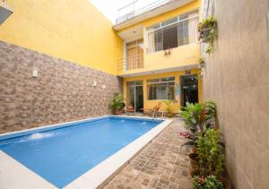 a swimming pool in front of a house at 102 RV APARTMENTS IQUITOS-APARTAMENTO FAMILIAR CON PISCINA in Iquitos