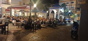 a group of people sitting at tables in a street at night at Apartamento Estudio Balcon in Almuñécar