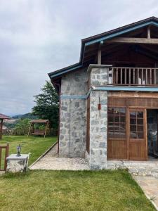 un grand bâtiment en pierre avec un garage en bois dans l'établissement My Villa, à Trabzon