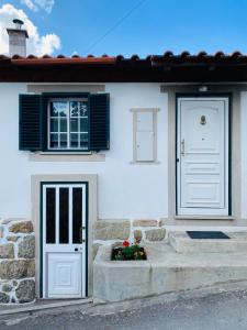 Casa blanca con puerta blanca y ventana en Casinha da Ti'Augusta, en Lamego