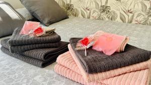 una pila de toallas sentadas encima de una cama en Acogedor loft en recinto privado - Terapia Salada, en Estepona