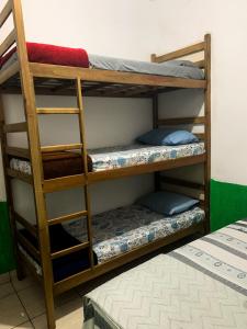 um quarto com três beliches num quarto em Guest House do Magoo em Arraial do Cabo