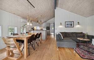 een keuken en een woonkamer met een tafel en een bank bij Beautiful Home In Nex With Sauna in Vester Sømarken