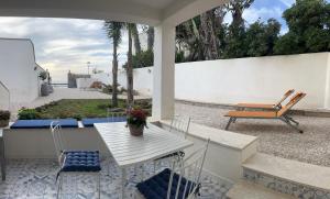 un patio con mesa, sillas y banco en Appartamento MARE in Villa Giulia sul Mare en Marausa