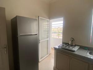 La cuisine est équipée d'un réfrigérateur en acier inoxydable et d'un évier. dans l'établissement Appartement neuf meublé dans le Centre d'Agadir, à Agadir