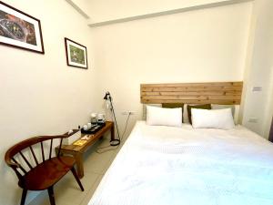 a bedroom with a bed and a chair and a desk at 給我拍拍寵物友善行館 in Taitung City +56 photos