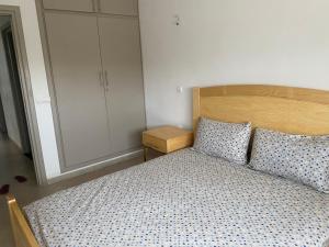 - une chambre avec un lit doté d'une tête de lit en bois et d'une armoire dans l'établissement Appartement neuf meublé dans le Centre d'Agadir, à Agadir