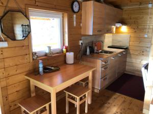 a kitchen with a wooden table in a cabin at Domekwroznowiepl in Rożnów