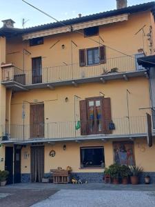 a large yellow building with windows and balconies at Casa Poldo in Cantello