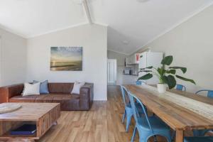 a living room with a wooden table and a couch at Reflections Mylestom - Holiday Park in Mylestom