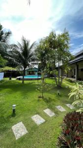 une cour verdoyante avec des arbres et un bâtiment dans l'établissement Ariella Mangrove & Eco Resort by Hiverooms, à Bulalacaw