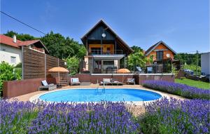 una casa con piscina y flores púrpuras en Nice Home In Sveti Ivan Zelina With Outdoor Swimming Pool, en Sveti Ivan Zelina