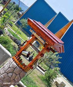 un banc en bois installé au-dessus d'un bâtiment dans l'établissement olive garden farm, à Ulcinj