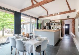 a kitchen and dining room with a table and chairs at The Cattle Barn in Wood Dalling