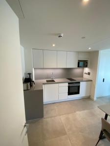 a kitchen with white cabinets and a sink at Ardwyn Studio Apartments Gibraltar in Gibraltar