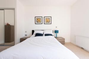 倫敦的住宿－Luxury Apartment Canning Town，卧室配有一张带两个枕头的大白色床