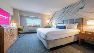 a hotel room with a large bed and a television at Circus Circus Reno, A Caesars Destination in Reno