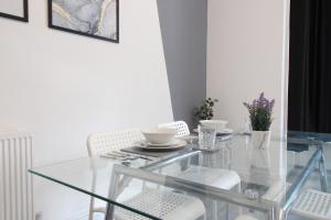 a glass dining room table with white chairs at Amazing - 1BDR - Free Street Parking in Wolverhampton