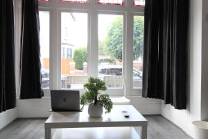 einem weißen Tisch mit einem Laptop vor einem Fenster in der Unterkunft Amazing - 1BDR - Free Street Parking in Wolverhampton