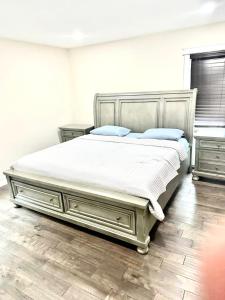 1 dormitorio con 1 cama grande con sábanas blancas y almohadas azules en Entire Cozy Home minutes away from PA., en Delaware Gardens