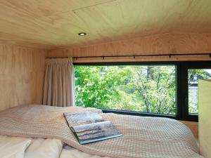 een bed in een kleine kamer met een raam bij TED Tiny House in Nunspeet