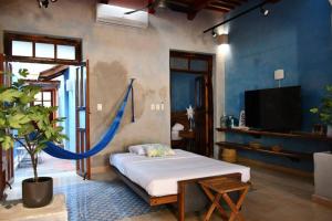 a bedroom with a bed and a tv in a room at Trilliza Azul in Campeche