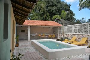 un patio trasero con piscina y una casa en Trilliza Azul, en Campeche