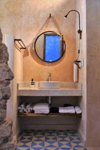 a bathroom with a sink and a mirror and towels at Trilliza Azul in Campeche