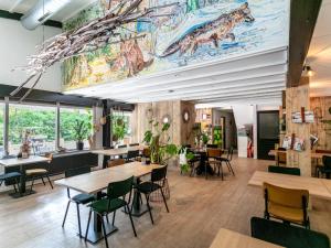 un ristorante con tavoli, sedie e un murale di TED Tiny House a Nunspeet