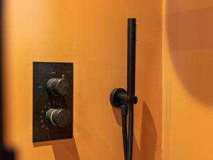 een zwarte deurknop op een oranje muur bij TED Tiny House in Nunspeet